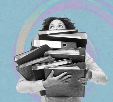 Woman carrying large pile of binders.