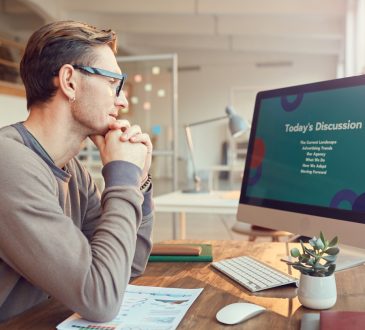 Side view portrait of adult businessman looking at computer screen while preparing for presentation