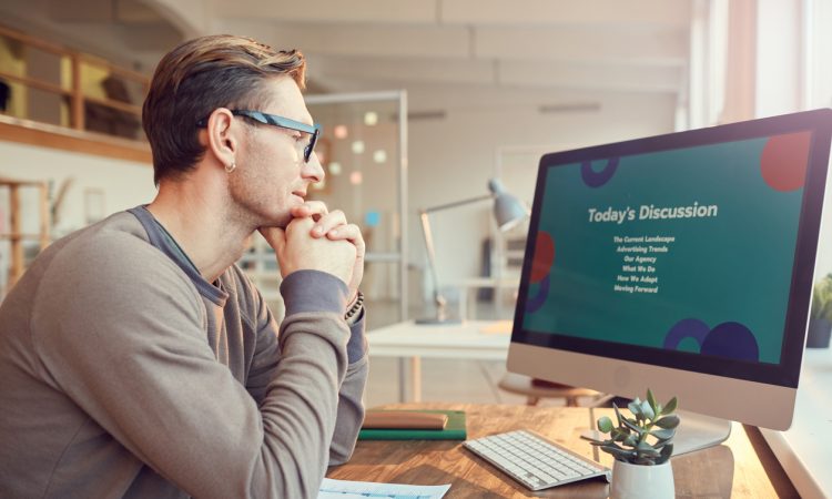Side view portrait of adult businessman looking at computer screen while preparing for presentation