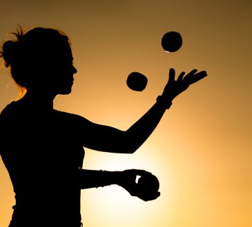 Silhouette of woman juggling
