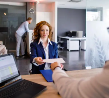 Woman handing man resume during job interview