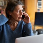 Woman stressed on phone call.