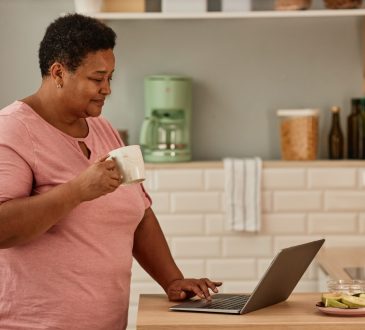 Woman using laptop in kitchen
