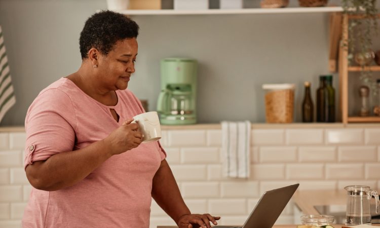 Woman using laptop in kitchen