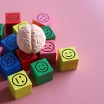 Human brain with blocks showing happy, neutral and sad icon.