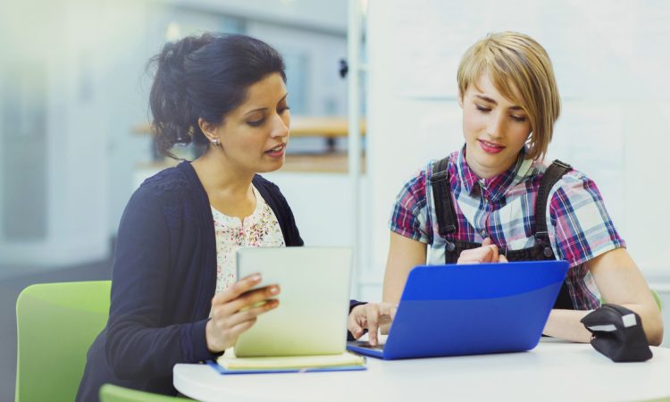 Student services professional working with student at desk