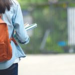 Back of student wearing backpack