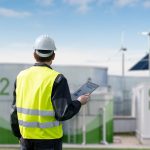Engineer with tablet computer on a background of Green Hydrogen factory