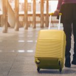 Woman traveller with luggage walking in airport