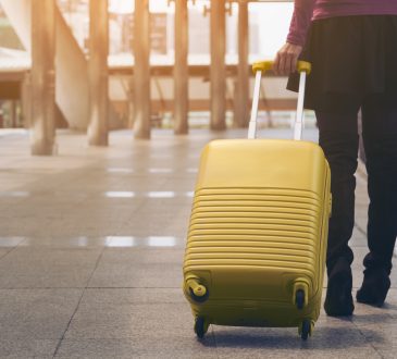 Woman traveller with luggage walking in airport
