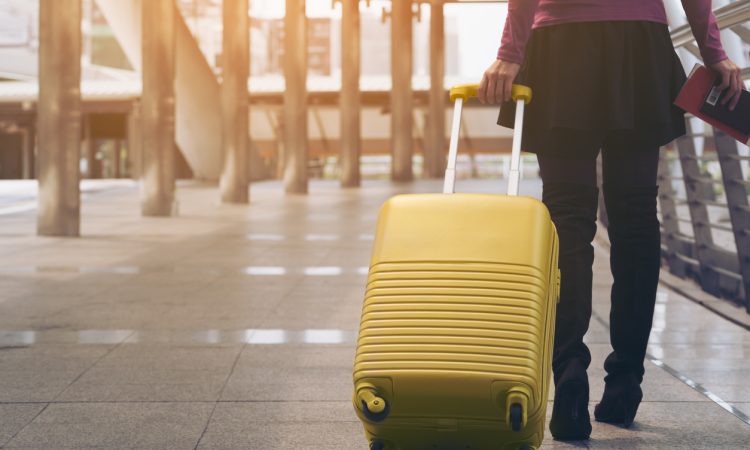 Woman traveller with luggage walking in airport
