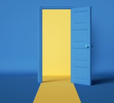 Yellow light emerging from open blue door