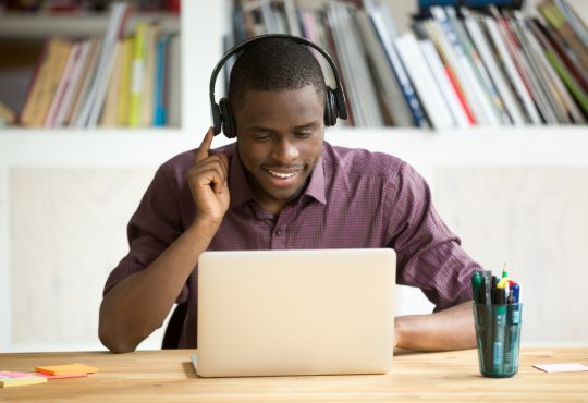 Man wearing headphones sitting at laptop
