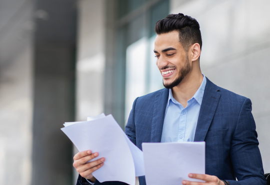 Man in blazer preparing for interview by reading papers