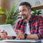 Portrait of middle aged man using tablet at home