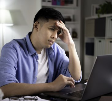 Man sitting at desk looking stressed