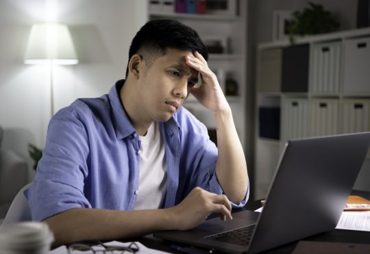 Man sitting at desk looking stressed