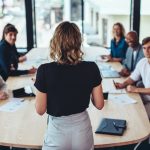 Woman delivering presentation in boardroom.
