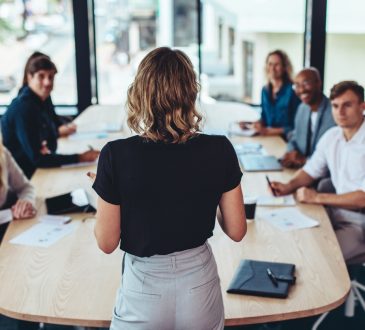 Woman delivering presentation in boardroom.