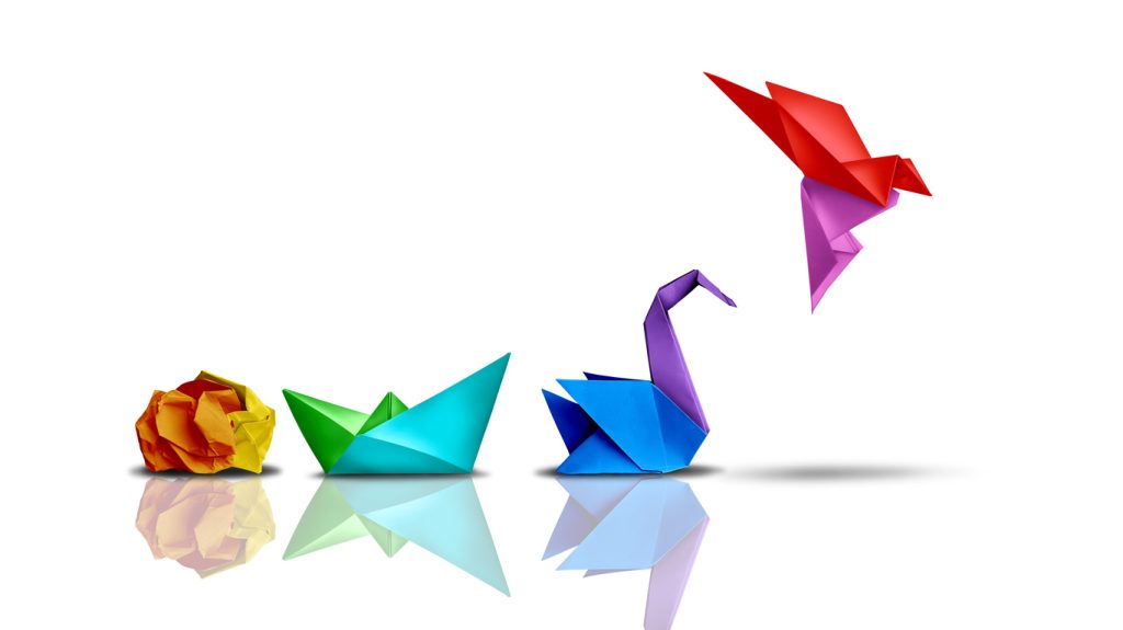 Colourful oragami showing crumpled paper ball, boat, swan and hummingbird, to suggest transformation