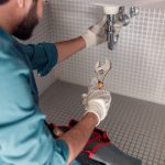 Worker is repairing bathroom sink