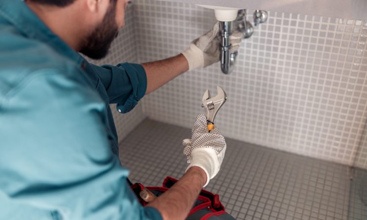 Worker is repairing bathroom sink