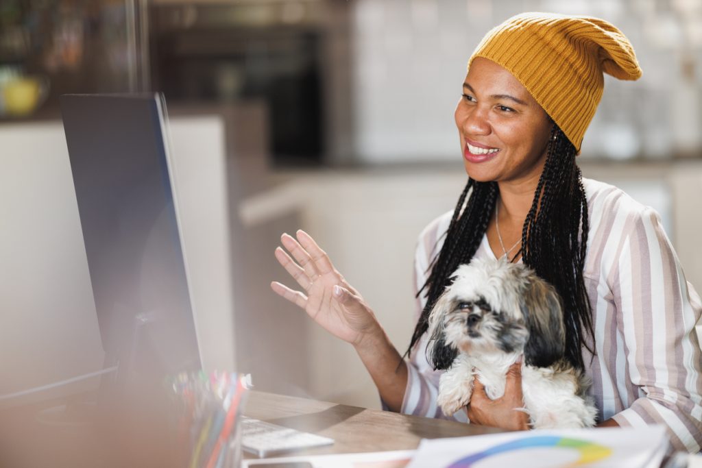 Woman holding dog while on video call