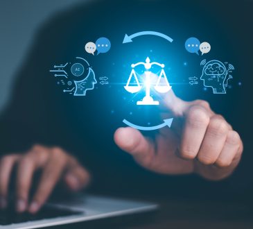 AI ethics concept. Person sitting at laptop, with finger pointing at scales of justice between symbols of AI and human head