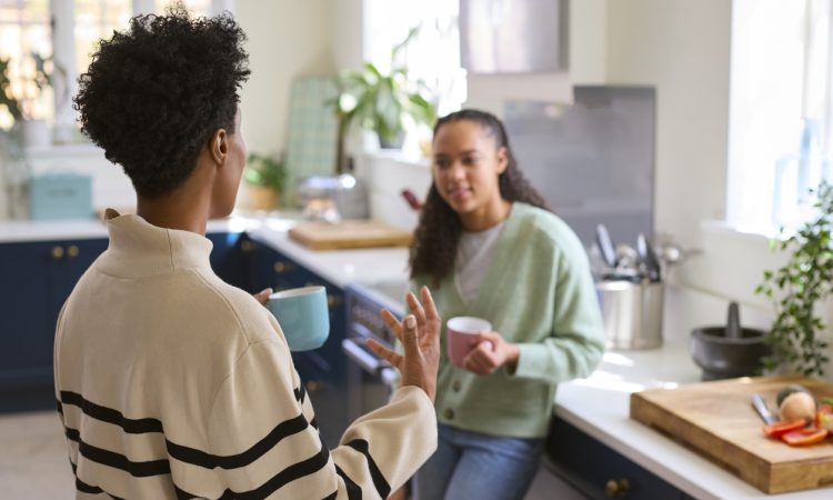 Mother Talking With Teenage Daughter At Home In Kitchen