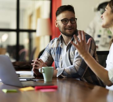Two people sitting and talking at work.