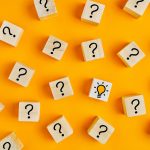 Wooden blocks with question marks on yellow background
