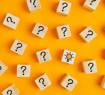 Wooden blocks with question marks on yellow background