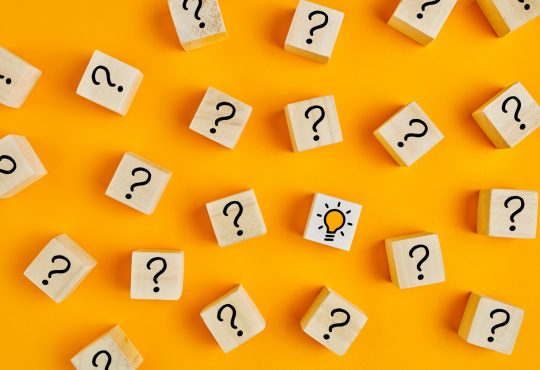 Wooden blocks with question marks on yellow background