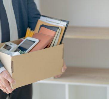 Man holding a box with several items.