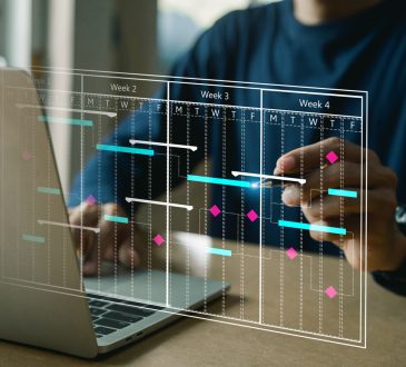 The image shows a person working on a laptop with a transparent digital overlay displaying a project timeline or Gantt chart, illustrating weeks of planned tasks and deadlines.