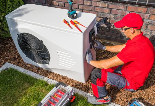 Photo of a HVAC technician fixing an AC.