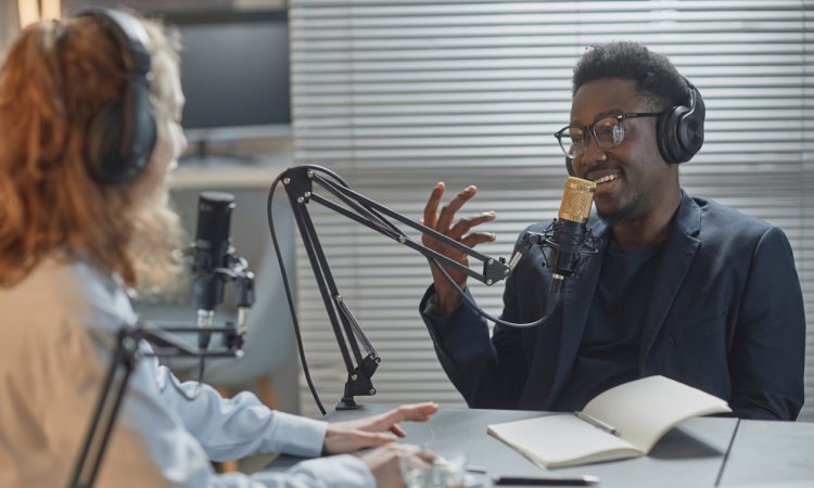 Two people recording podcast with stand mic
