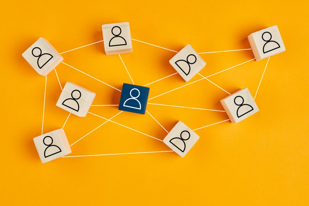 Wooden blocks with people icons on yellow background.