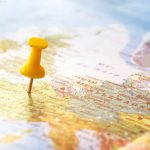 Yellow pin sticking into world map