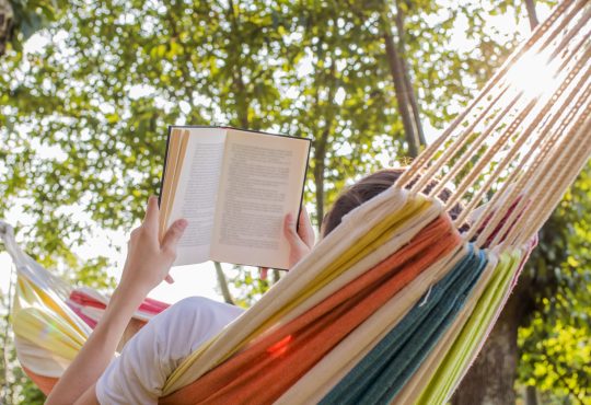Person reading in hammock