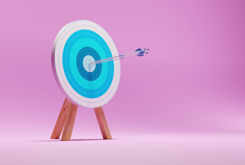 Archery target on a pink background.