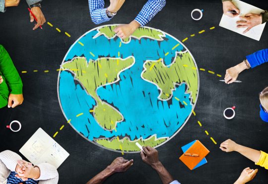 People sitting around drawing of globe