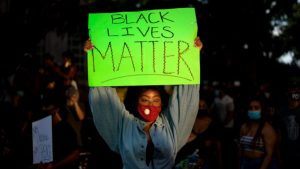 Image of woman holding up Black Lives Matter sign at protest