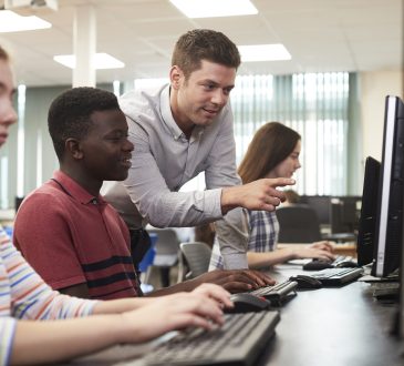 Teacher helping students in computer lab