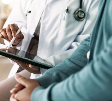 Closeup of hands of doctor looking at tablet