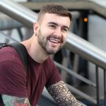 Young man sitting on stairs smiling