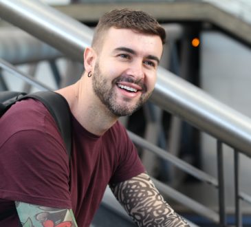 Young man sitting on stairs smiling