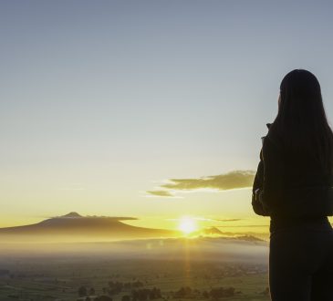 Woman facing sunrise